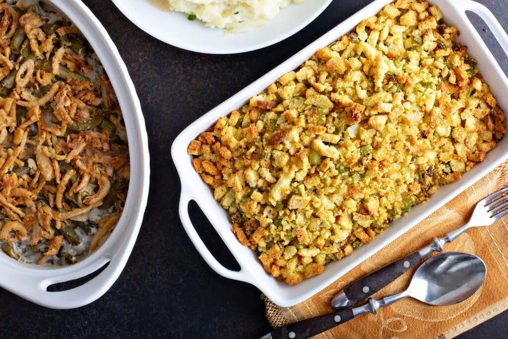 Southern Dressing: A Classic Cornbread Dish 2 southern dressing in a white pan beside of green bean casserole