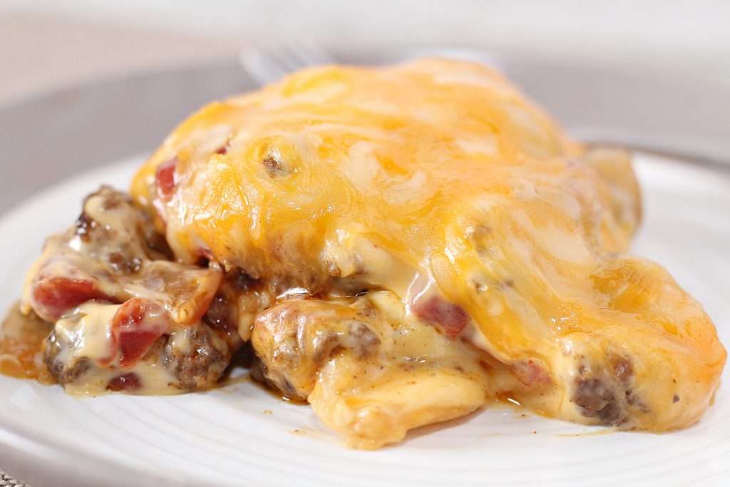 Close up of cheesy taco casserole on white plate. 
