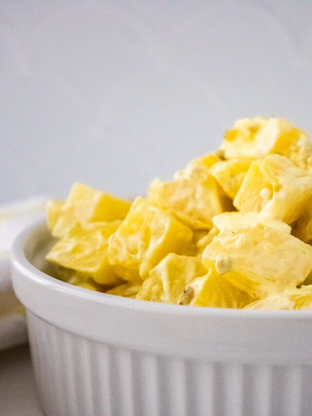 Southern Potato Salad in a white serving bowl, white and yellow checkered kitchen towel.