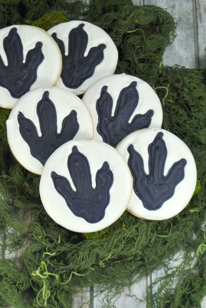 Dinosaur Cookies 4 Dinosaur cookies on green material that resembles moss.