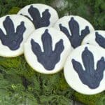 Dinosaur cookies on green material that resembles moss.