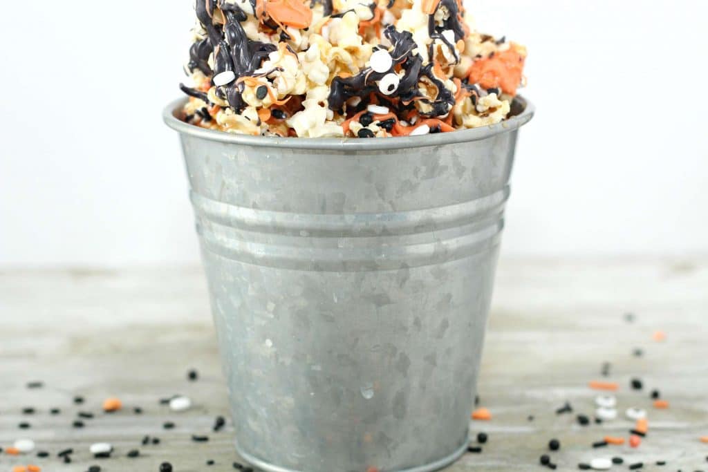 Halloween Popcorn 7 Halloween popcorn in a metal bucket on a wooden countertop.