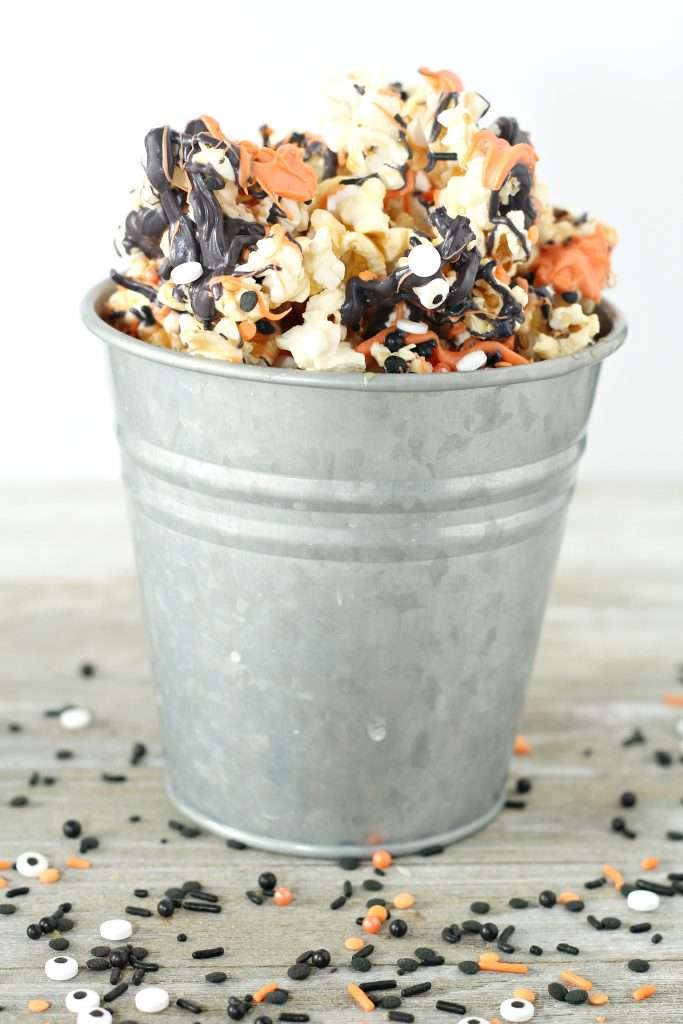Halloween Popcorn 2 Halloween Popcorn in a metal bucket on a wooden countertop.