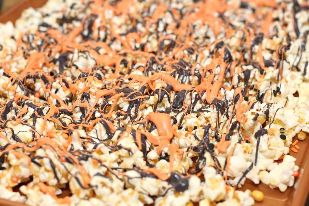 Halloween Popcorn 6 Freshly popped popcorn with black and orange melted chocolate.