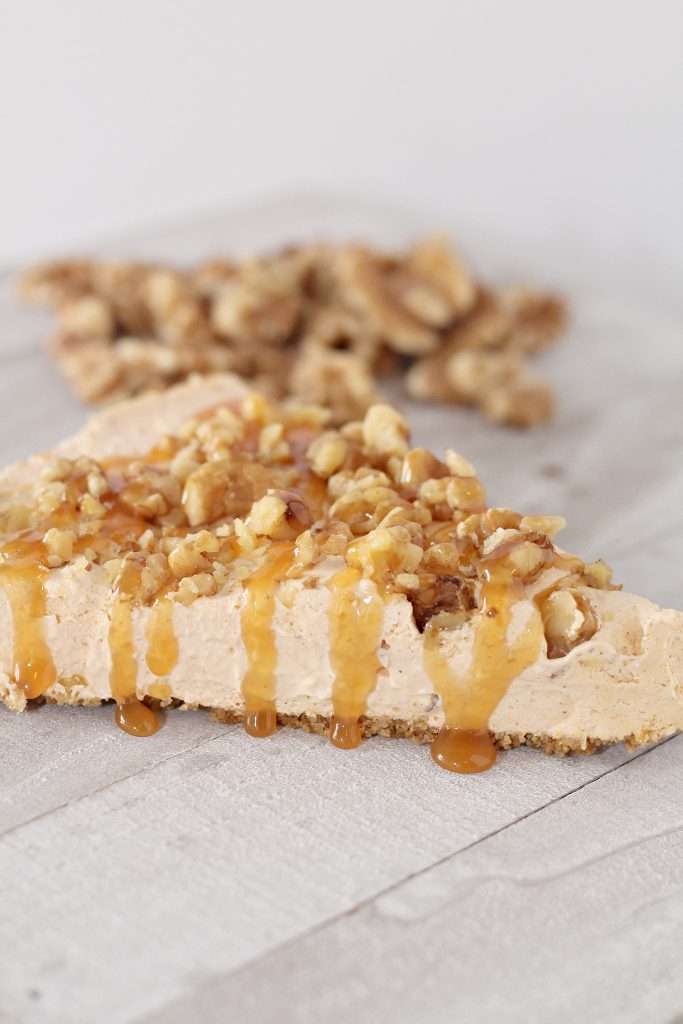 No Bake Pumpkin Cheesecake 2 Slice of no bake pumpkin cheesecake topped with chopped walnuts and caramel topping.