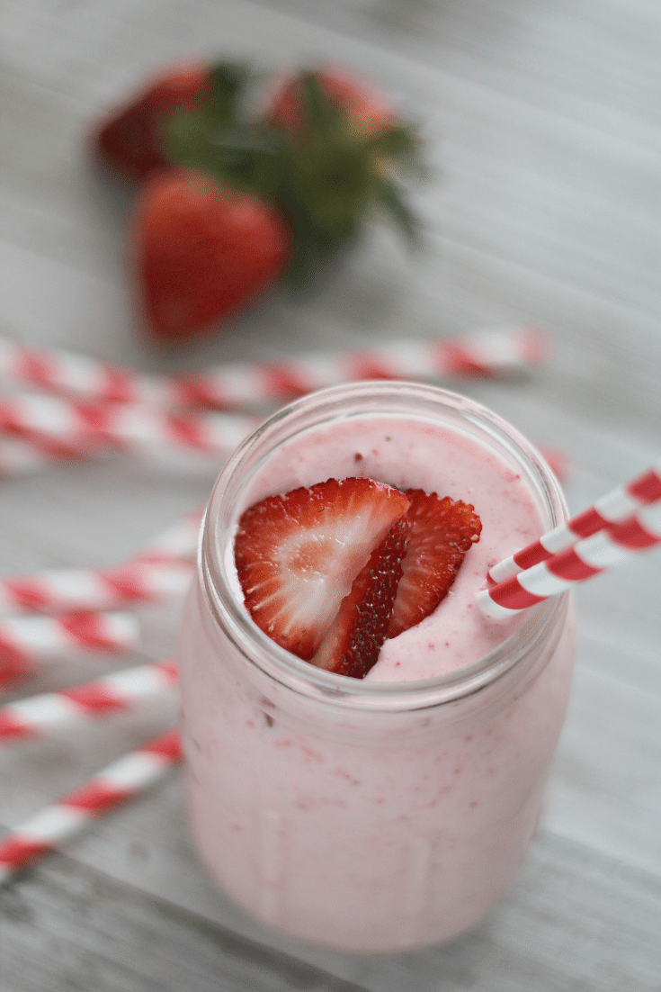 strawberry lemonade shake in mason jar with red and white striped straw