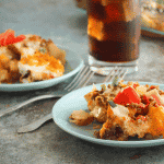 Taco potato bake on blue plates with forks and drink