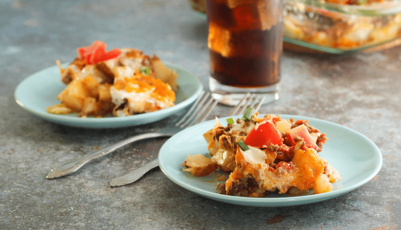 Taco potato bake on blue plates with forks and drink