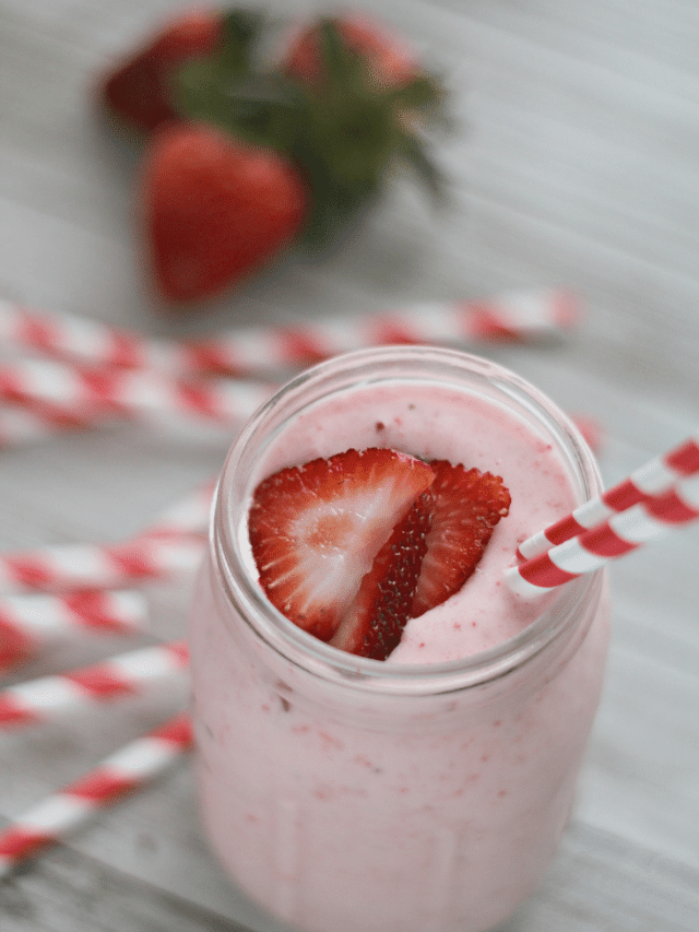 strawberry lemonade shake in mason jar with red and white striped straw