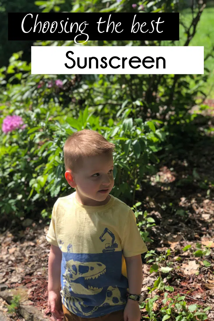 child outside, standing in front of bushes