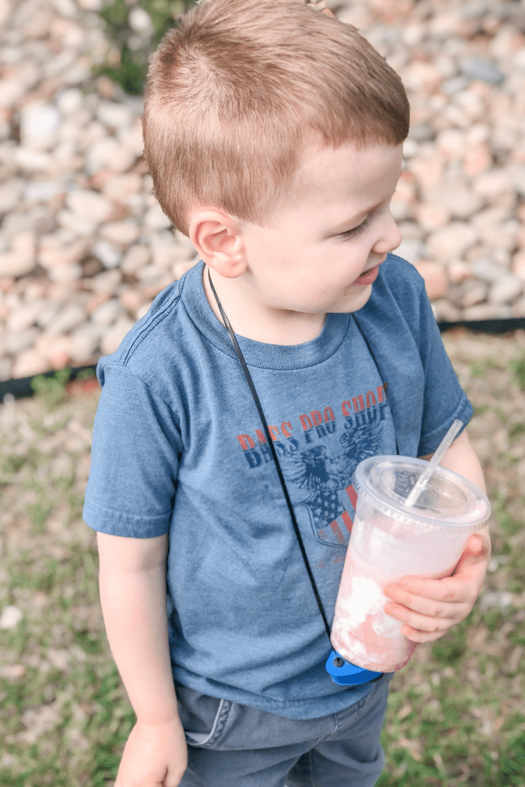 child holding drink and smiling