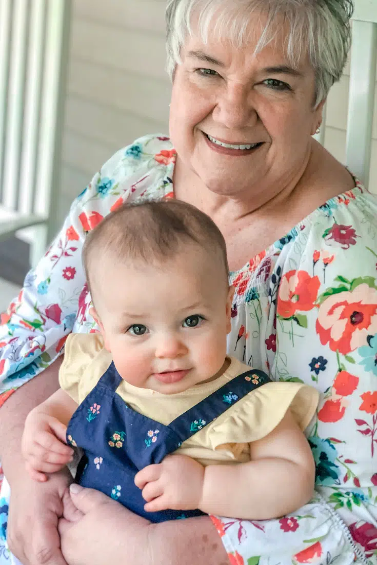 grandma holding baby and smiling