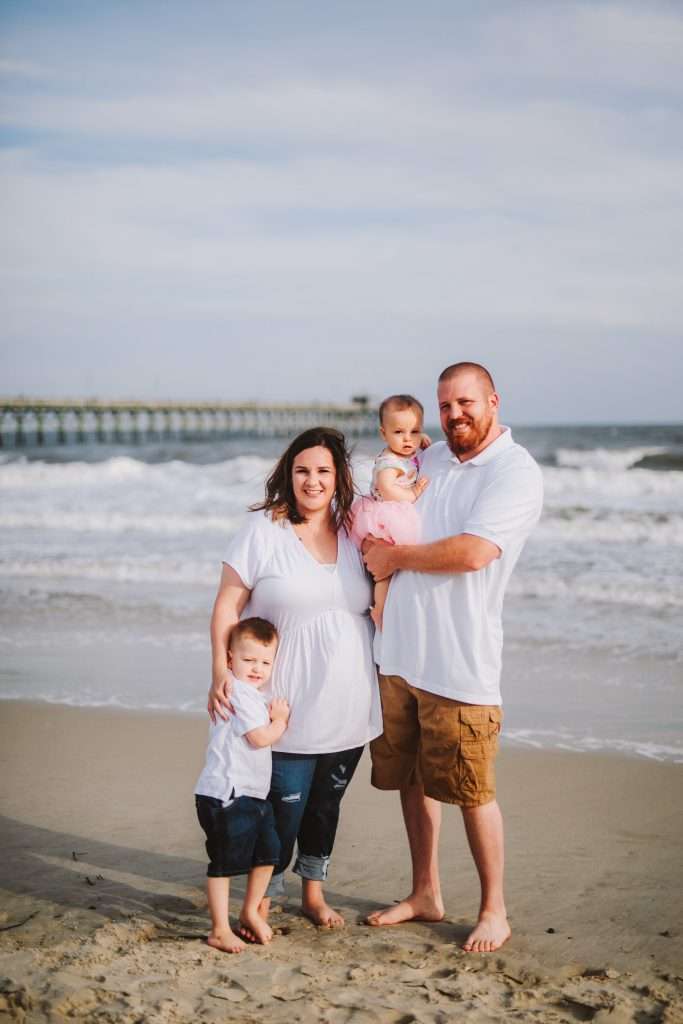 Family on beach in matching white shirts
