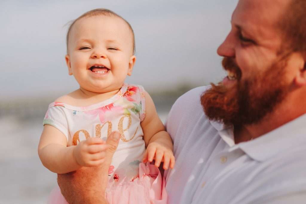 One year old laughing on beach at cake smash session
