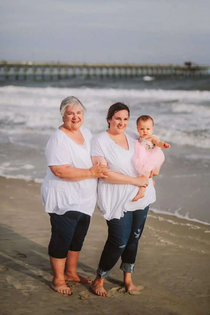 Three generation mom daughter and granddaughter photo on beach in matching clothes