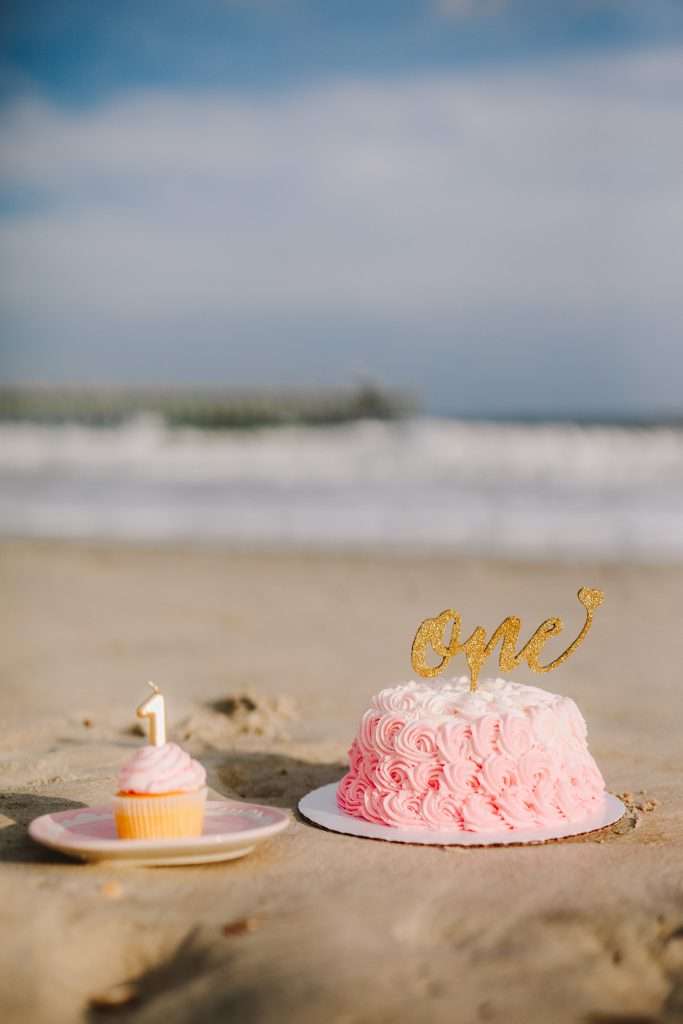 Pink rosette first birthday cake with gold glitter cake topper