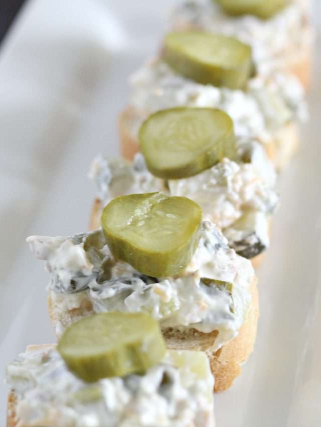 dill pickle dip up close on pieces of bread in line on white platter 