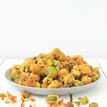 white plate of fried okra on wooden background