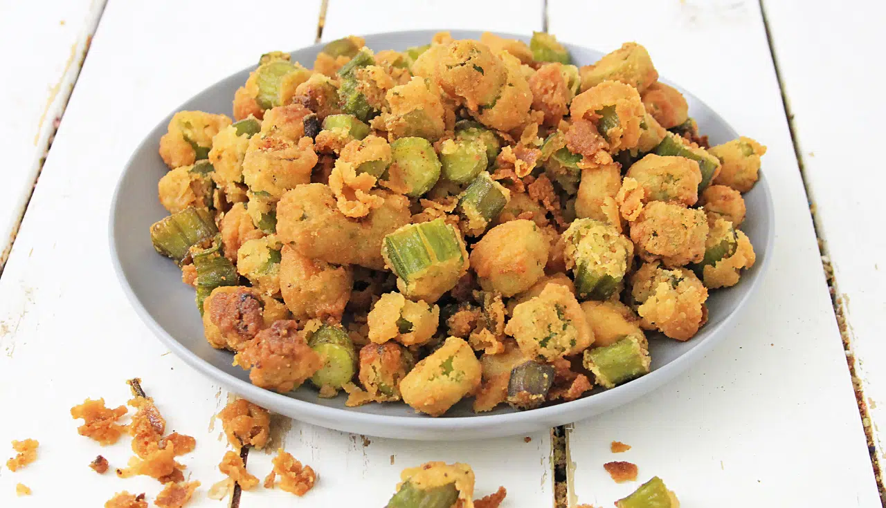 white plate of fried okra on wooden background