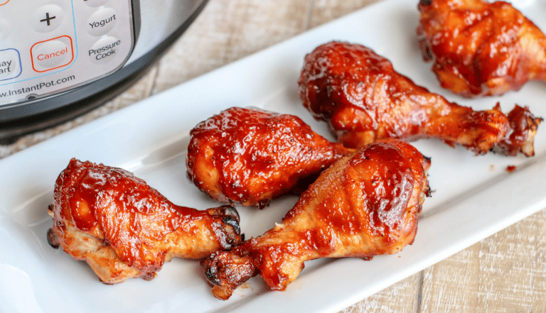 BBQ chicken legs on white glass plate 