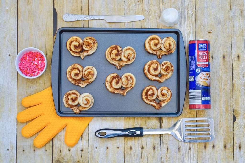 Heart shaped cinnamon rolls ready to bake for Valentine's Day on baking sheet