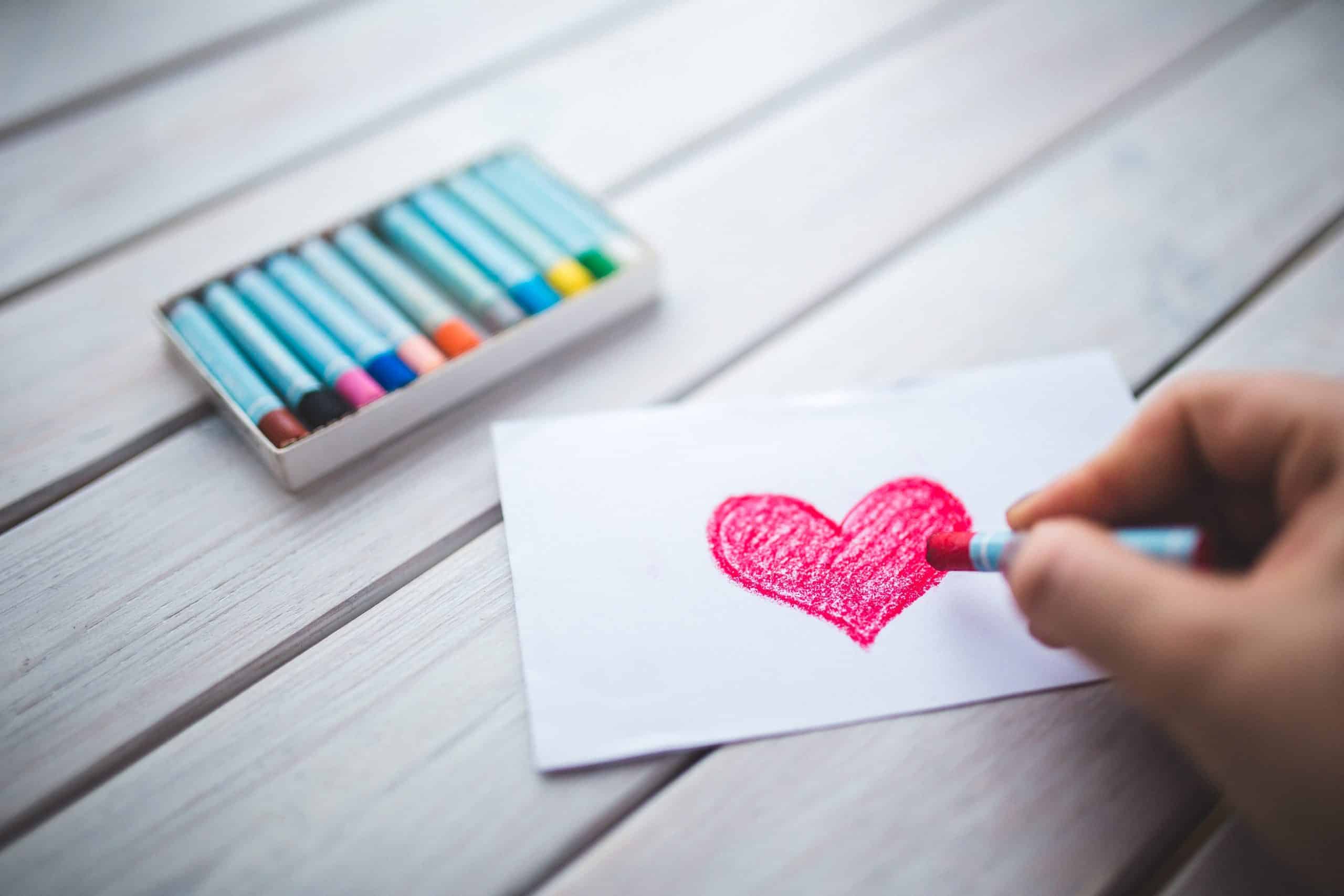 hand with oil pastel draws the heart 6333 scaled