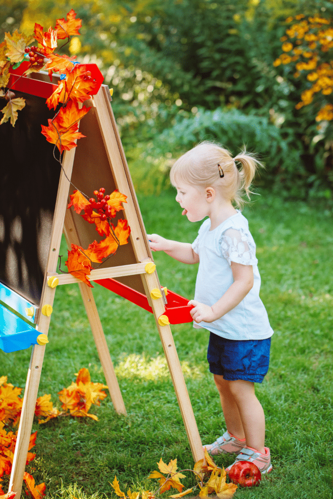 Outdoor Activities To Enjoy With Your Toddler 7 little girl painting at an easel