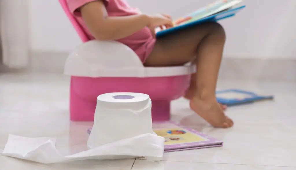 little girl on pink potty chair