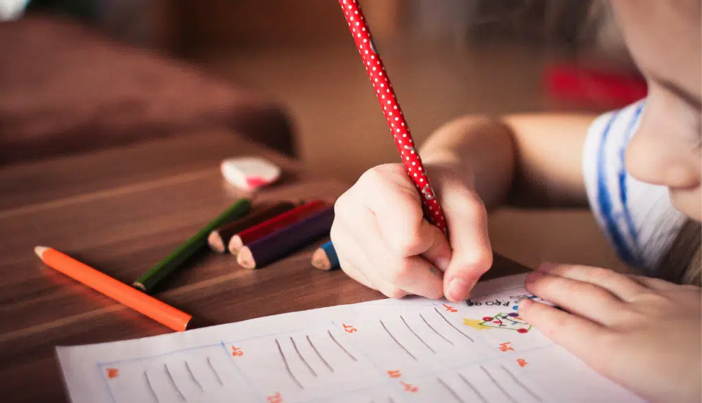 child writing on workbook