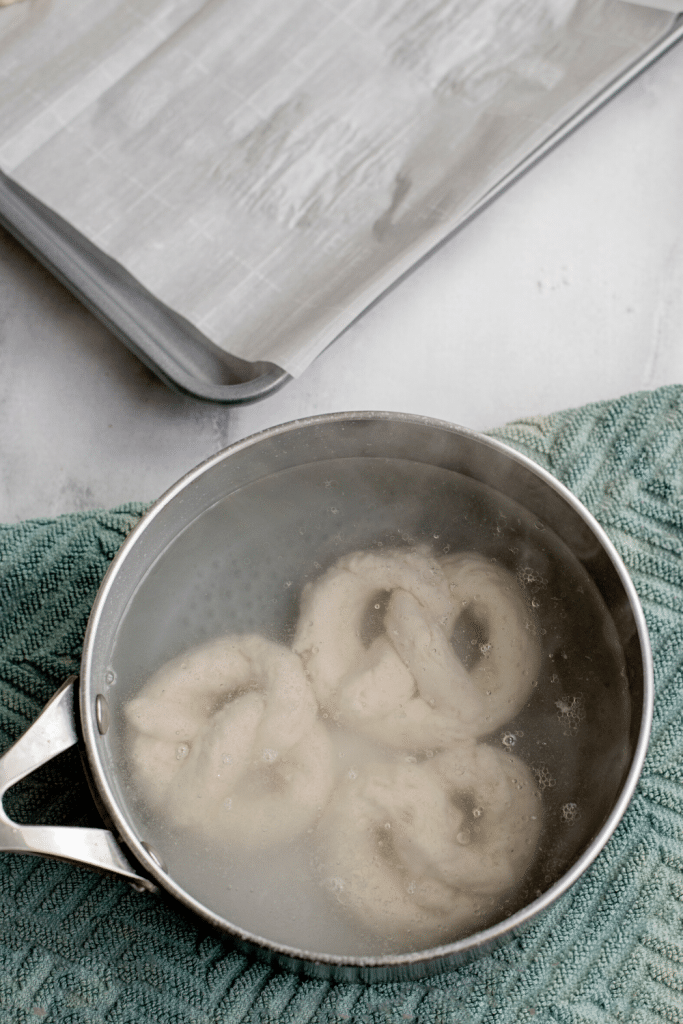 Soft Pretzels with Biscuit Dough 18 High angle shot of three frozen pretzel doughs in baking soda water in a pot.