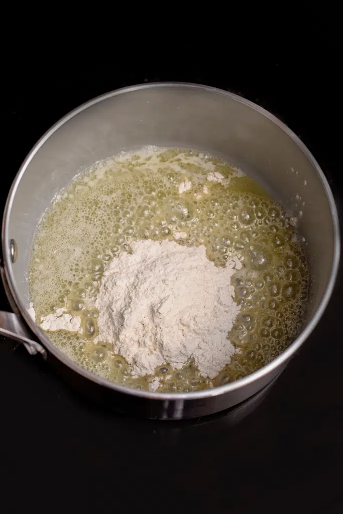 Flour added to melted butter in a pot.