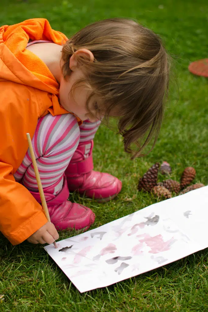 little girl paining outside