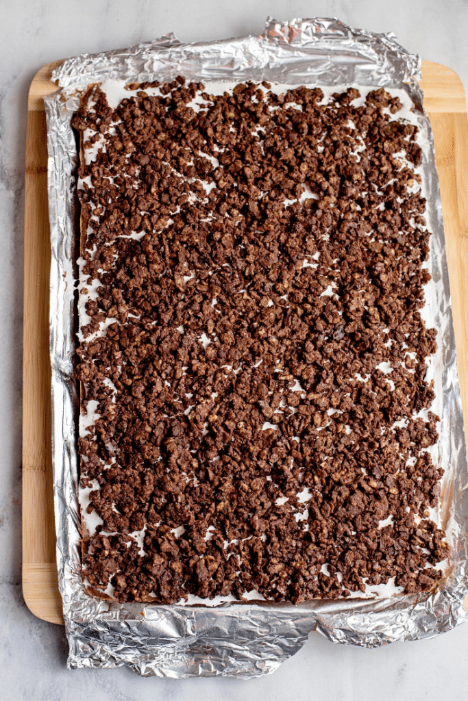 Chocolate Marshmallow Bars 24 Overhead view of assembled chocolate marshmallow bars in a baking pan on a wooden board.