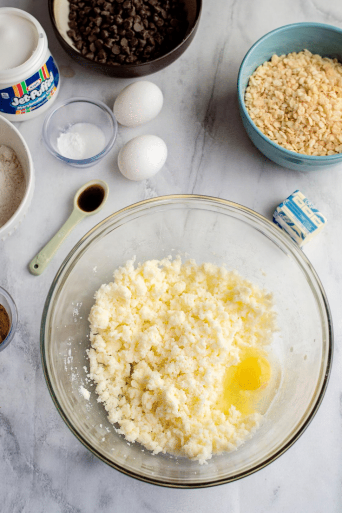 Chocolate Marshmallow Bars 12 Eggs added to the whipped butter and sugar mixture in a glass mixing bowl.