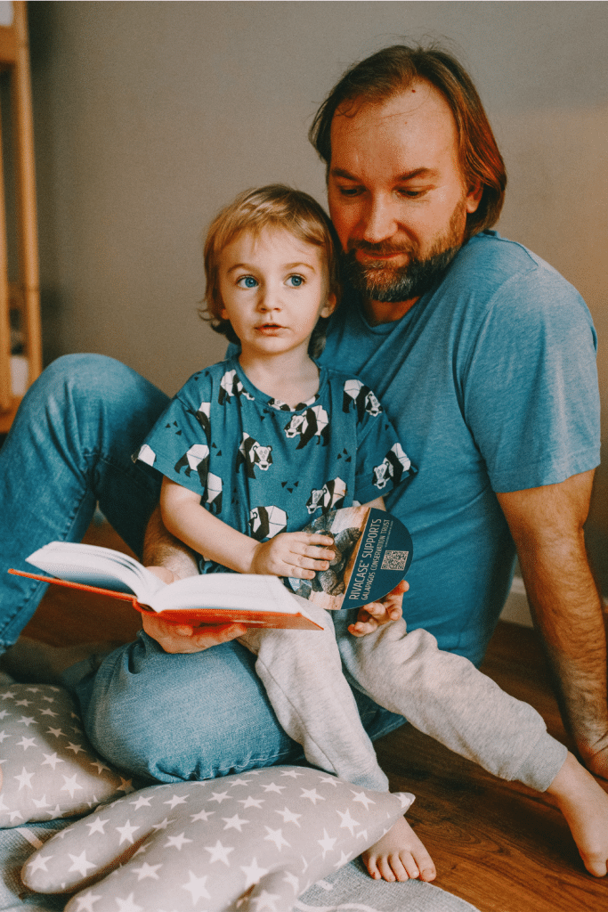 8 Strategies for Successful Homeschooling 7 child sitting on dads lap while dad reads to them