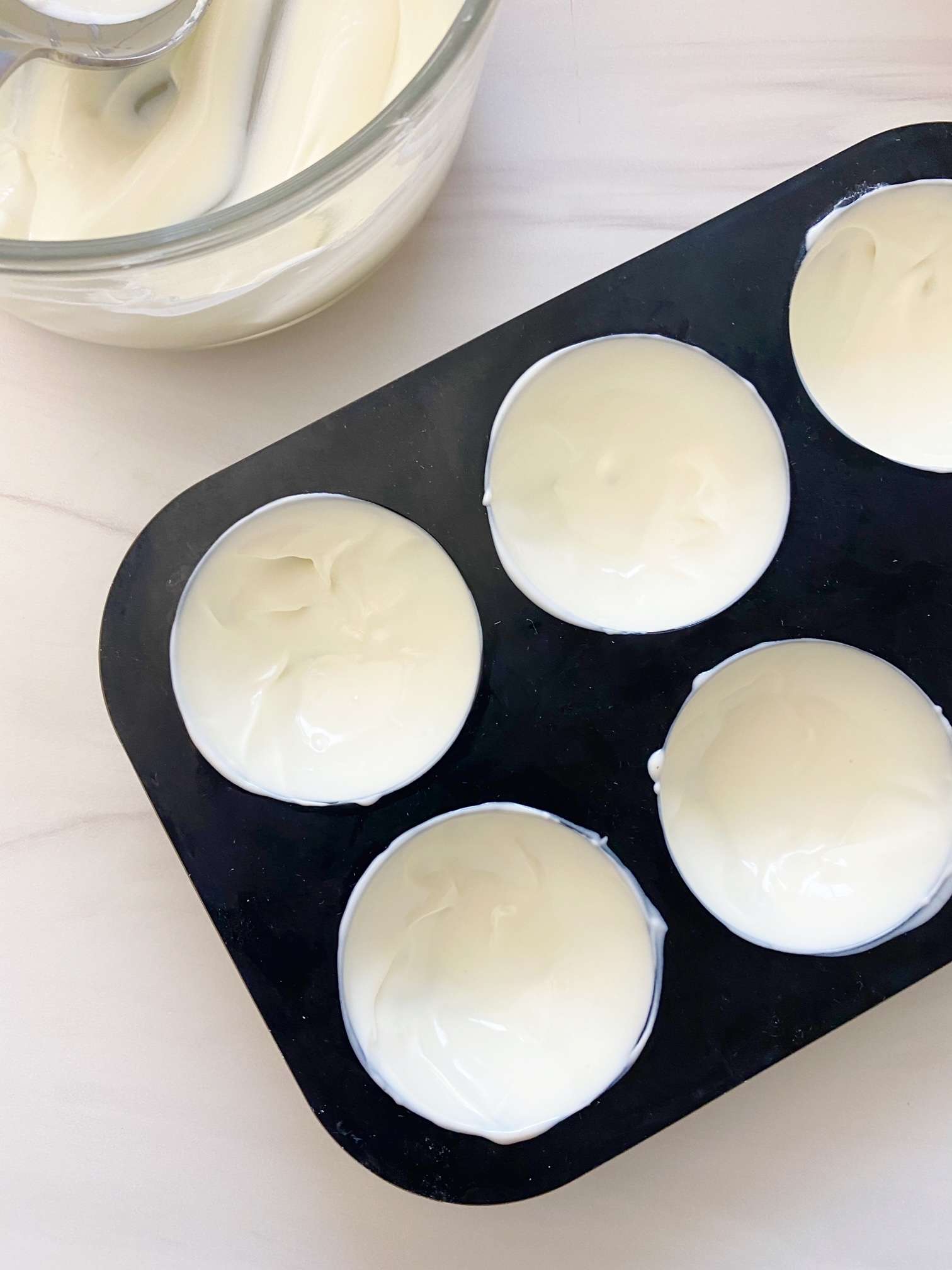 Melted white chocolate wafers in cocoa bomb mold