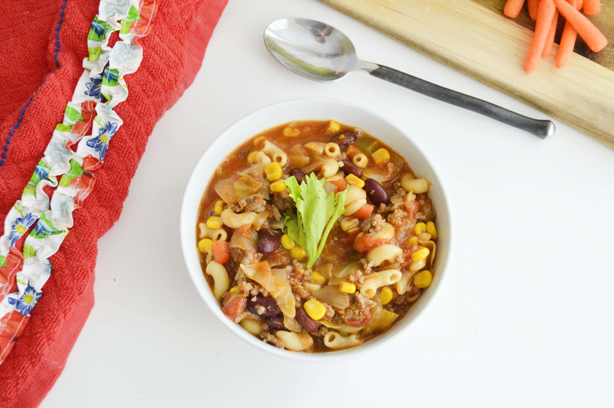 Minestrone Soup on white table with spoon to right of bowl