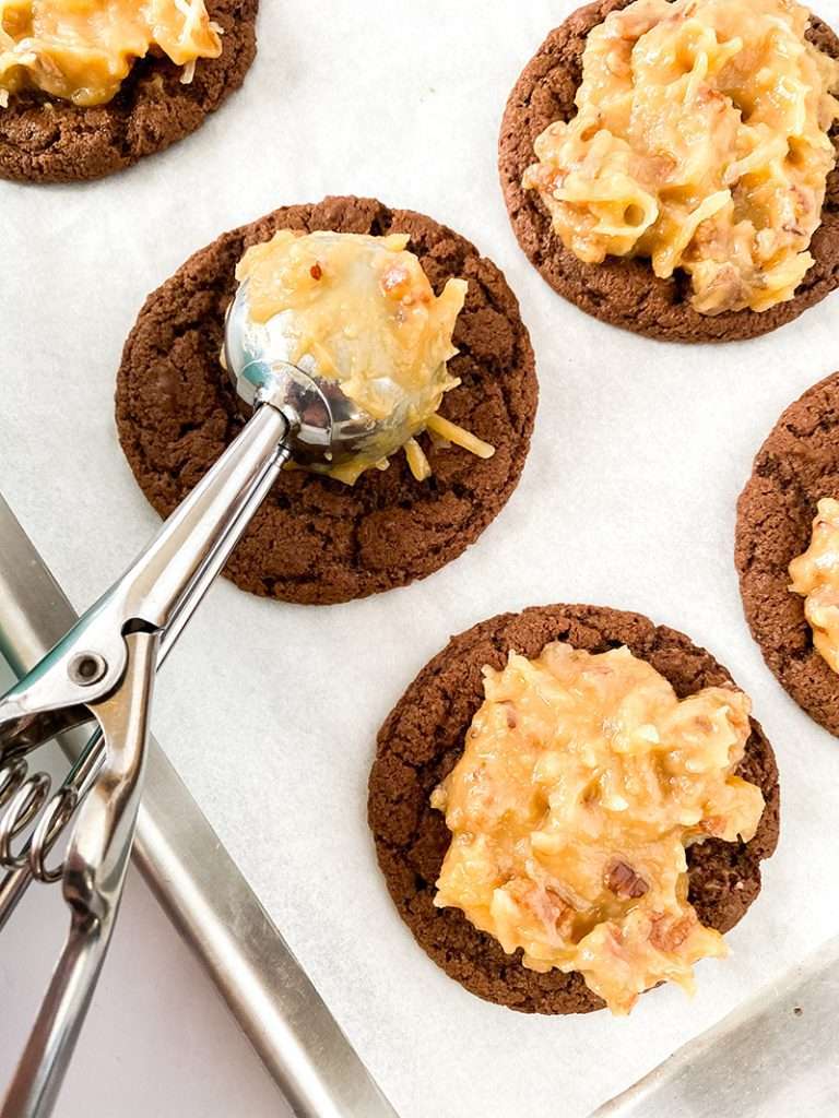 Topping German chocolate cookies with coconut pecan frostinig