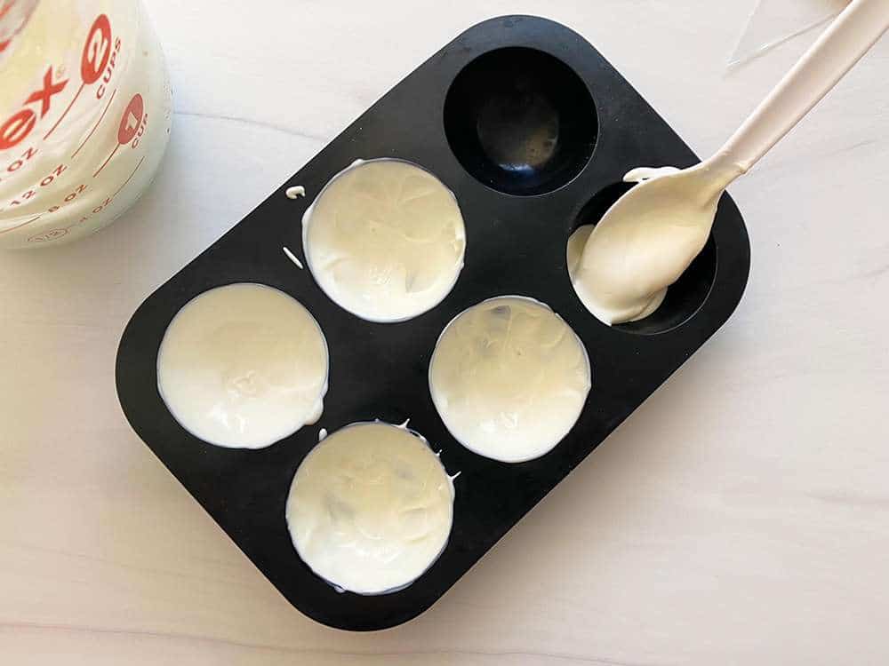 White chocolate being placed into sphere molds