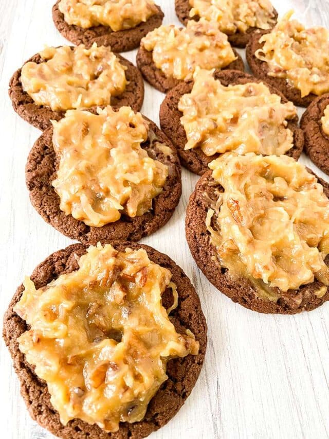 German chocolate cookies with coconut pecan frosting on a light wooden surface.