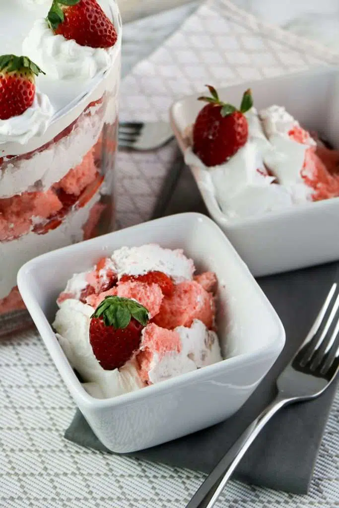 Strawberry trifle served in a white bowl with silver fork