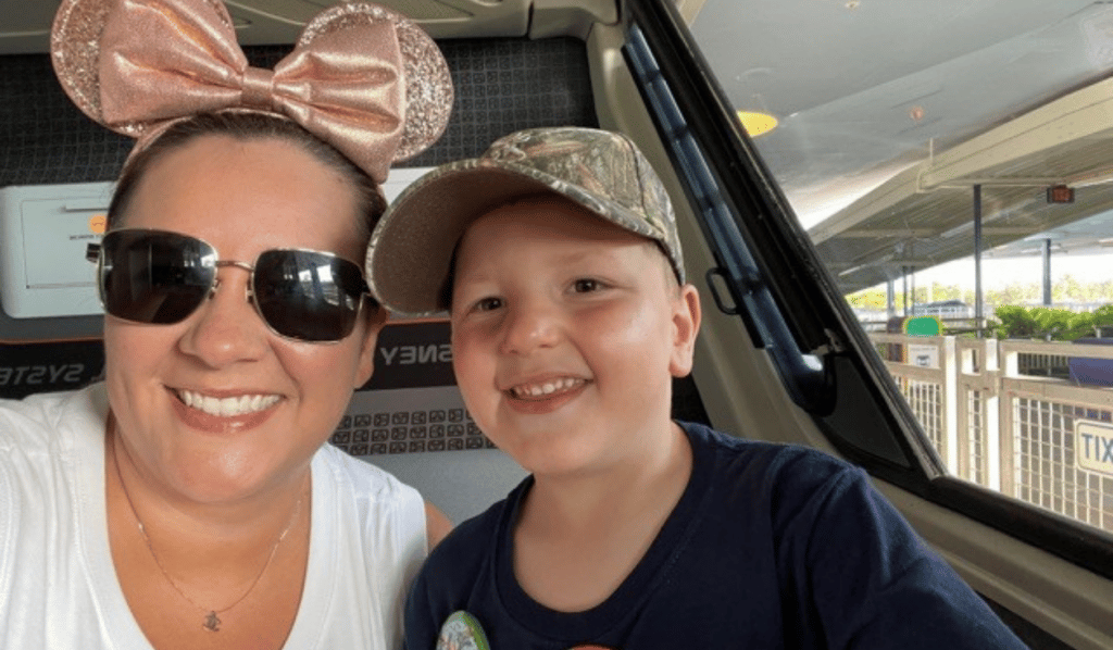 5 Ways to Save Money with Kids in Orlando 4 mom in mickey mouse ears and sunglasses next to son in hat with blue shirt smiling together