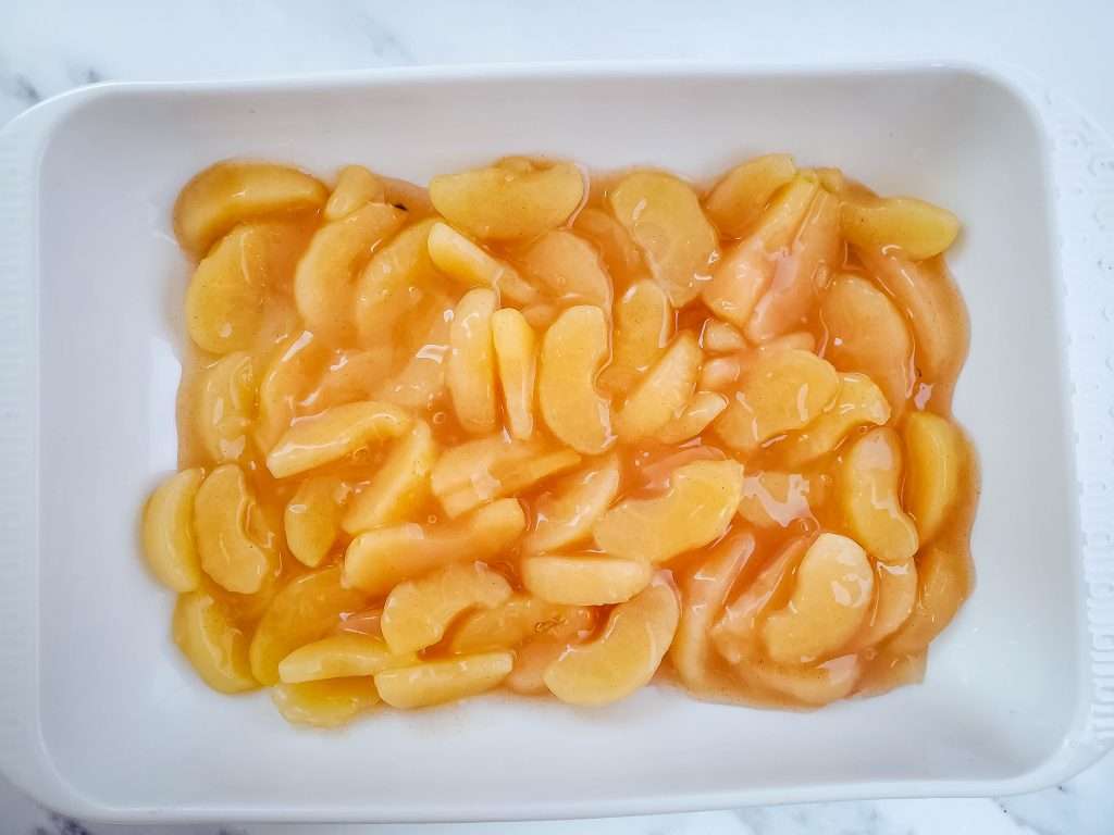 Apple Dump Cake 10 Apple pie filling in a white baking dish.