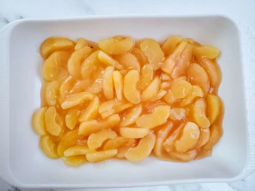 Apple pie filling in a white baking dish.