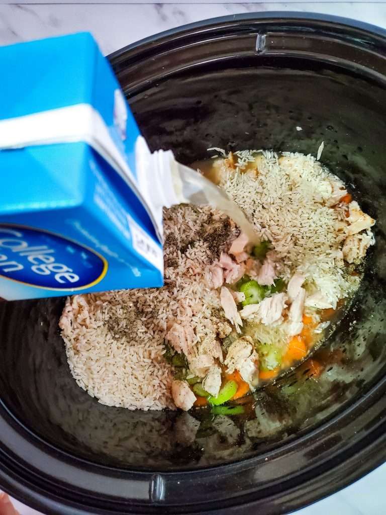 turkey broth getting poured on leftover turkey soup ingredients 