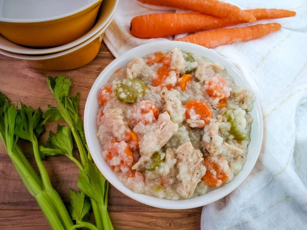 crockpot turkey and rice soup in a bowl with carrots and celery