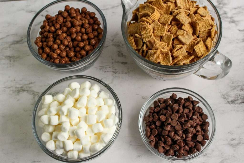 S’mores Cereal Snack Mix 7 ingredients for the S’mores Cereal Snack Mix in bowls