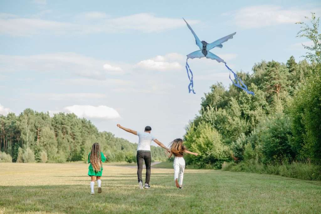 10 Fun Family Things to Do For Free 6 family flying a kite together in the park