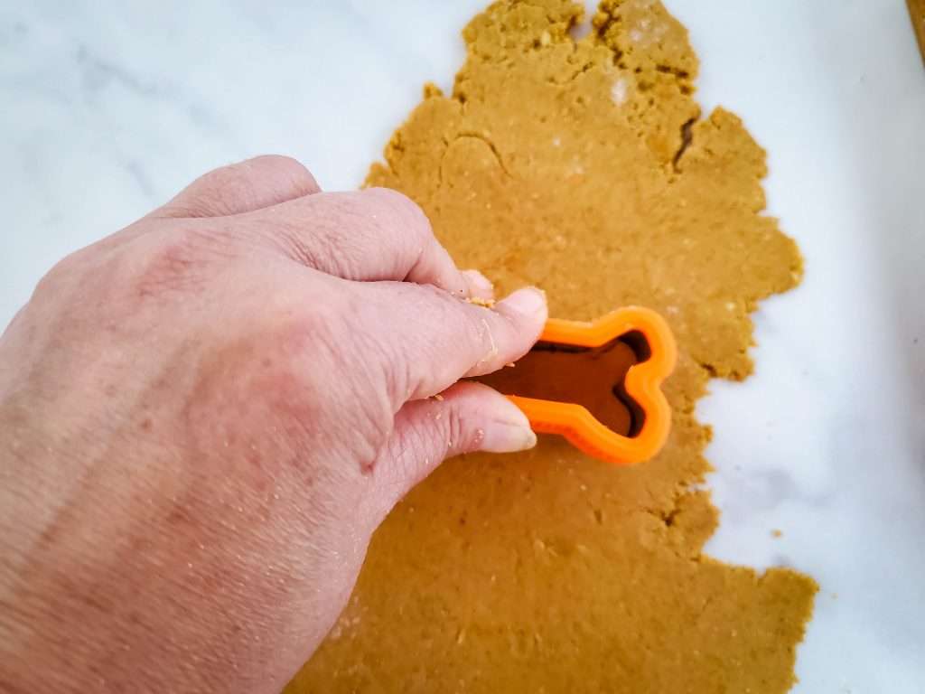 Dog bone shapes cut out of the rolled out dough using a bone cookie cutter.