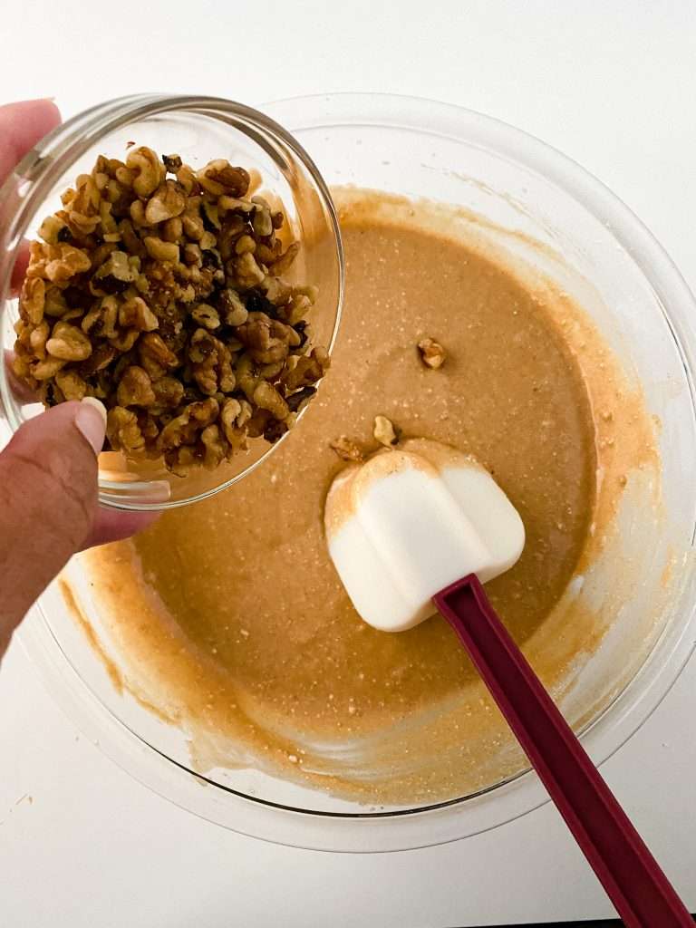 Apple Cider Cupcakes 9 Apple Cider Cupcakes batter in a mixing bowl, small bowl of chopped walnuts being added to the mixture.